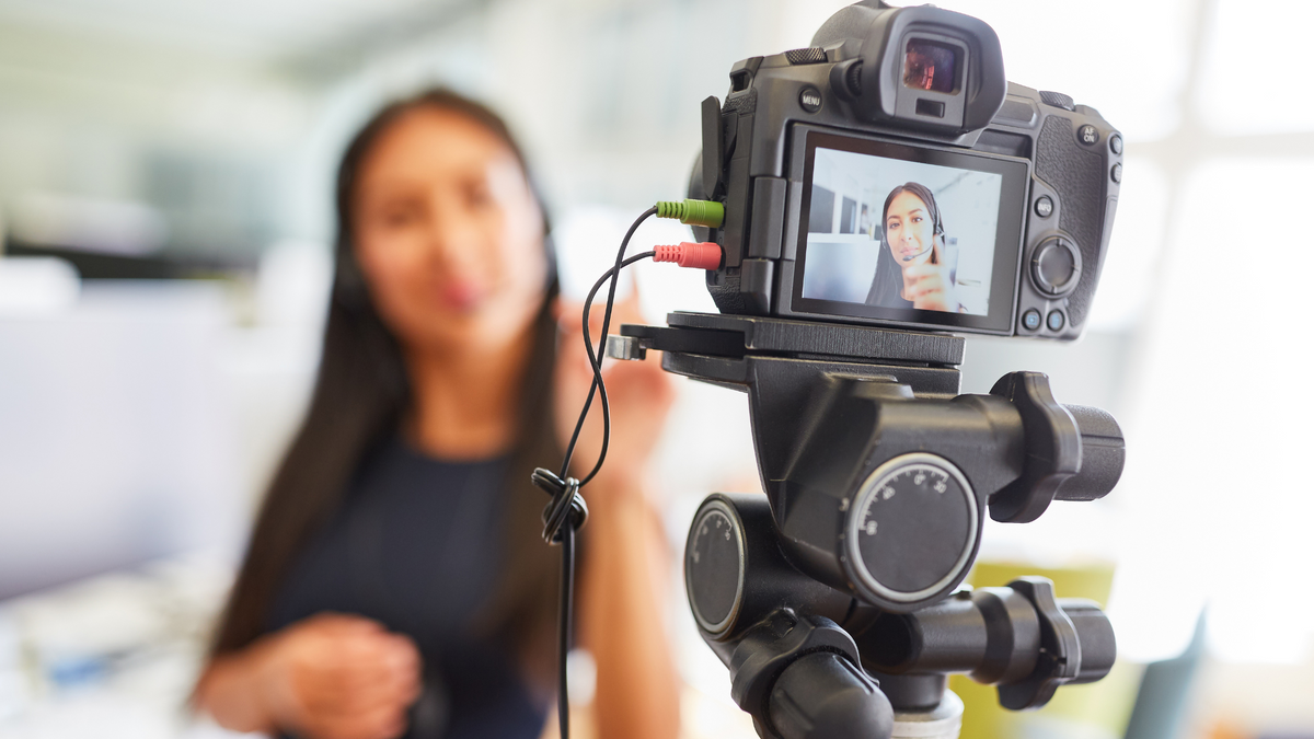 Business owner recording videos with a camera, to boost customer success.